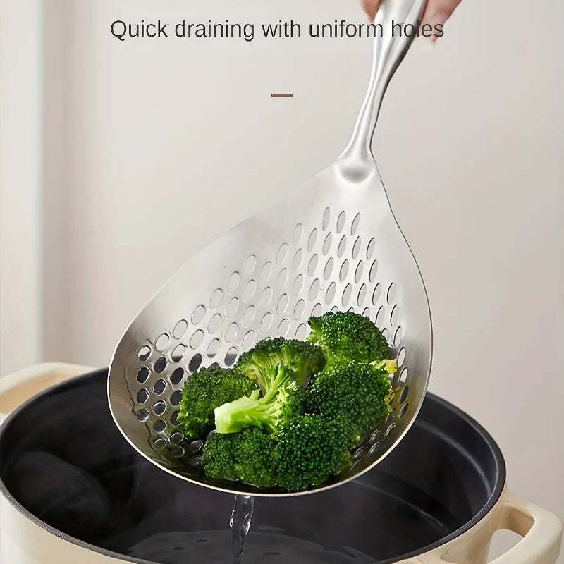 Metallic slotted spoon with broccoli being used to drain water from a pot.