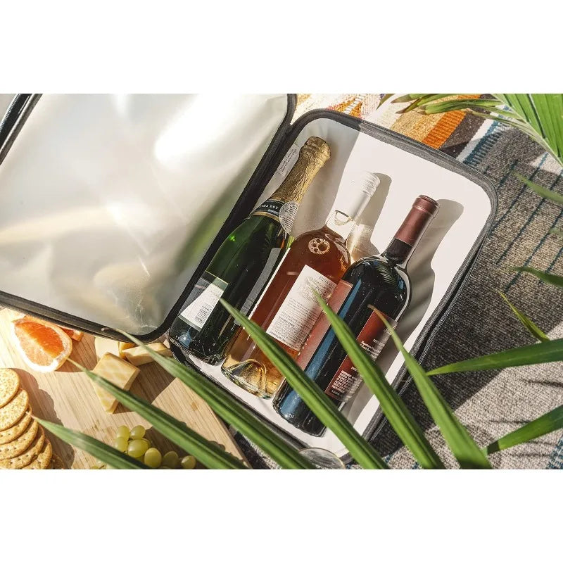Wine bottles in a cooler with snacks and fruit on a picnic blanket
