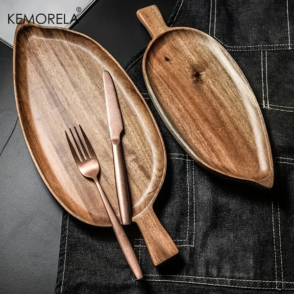 Wooden serving platters with cutlery on a dark surface, featuring the KEMORELA brand.
