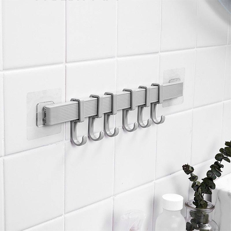 Multifunction kitchen storage hook with six hooks installed on a tiled wall.