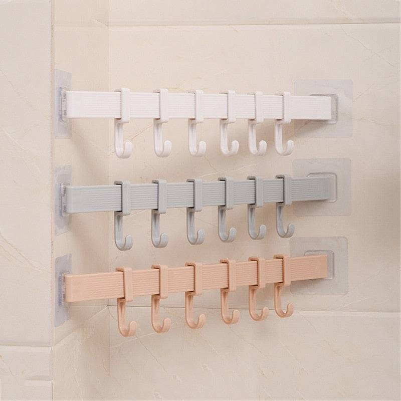 Multifunction kitchen storage hook with 6 hooks in three colors, mounted on a wall.