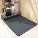 Large black kitchen drying mat next to coffee maker, super absorbent and non-slip.