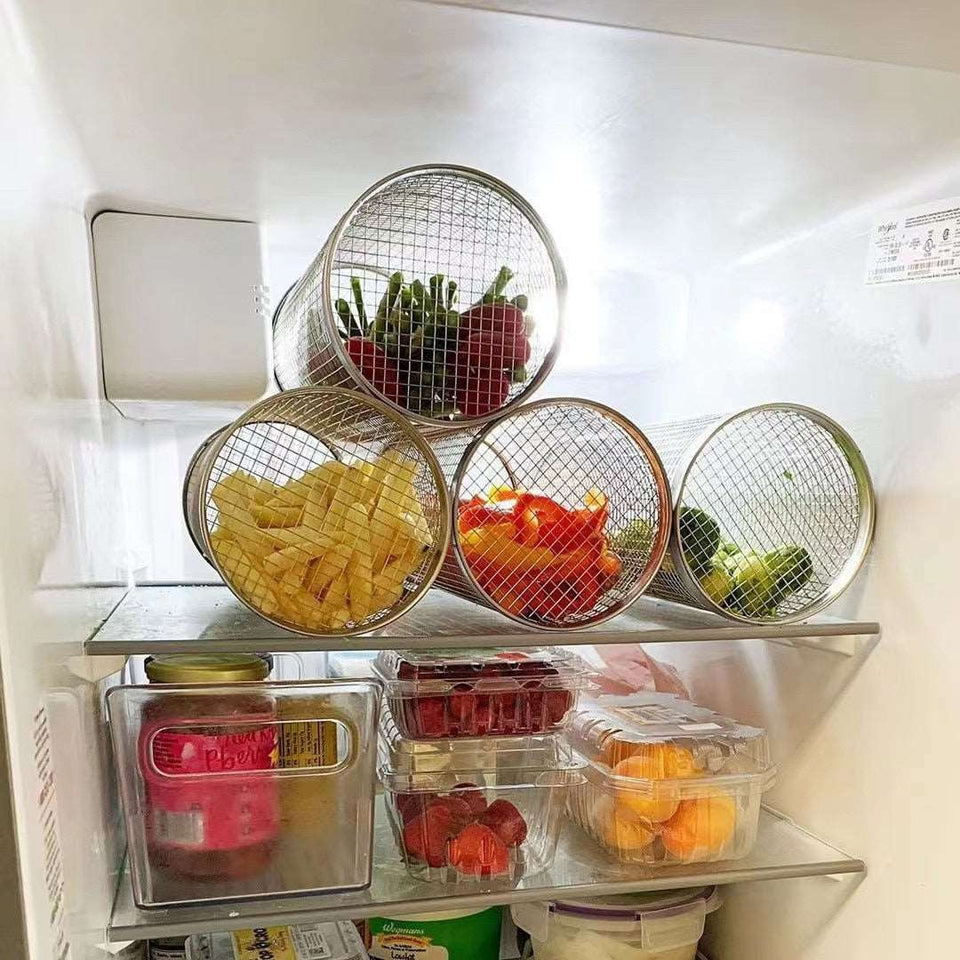 Stainless steel rolling grilling basket storing vegetables in a fridge.