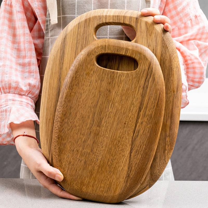 High-quality wooden chopping board held by person, ideal for versatile kitchen tasks.