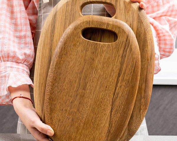 High-quality wooden chopping board held by person, ideal for versatile kitchen tasks.