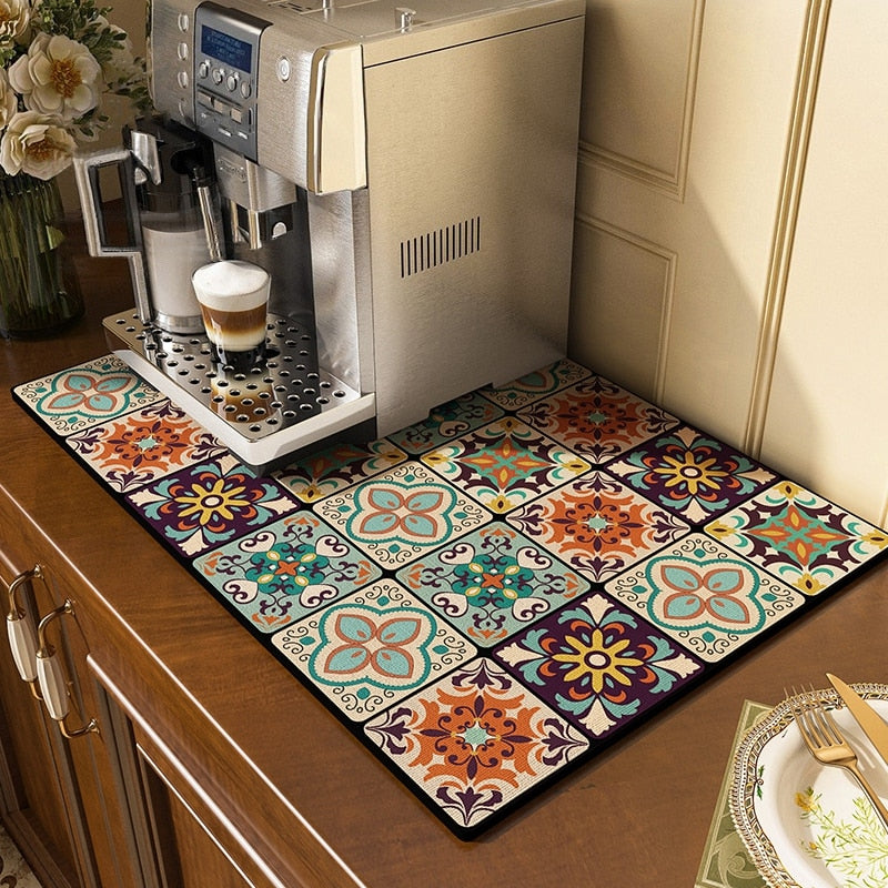 Kitchen dish drying mat with colorful pattern under a coffee machine on a wooden countertop.