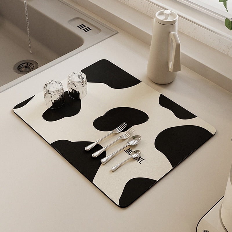 Kitchen dish drying mat with black and white design, absorbent and non-slip for efficient drainage.