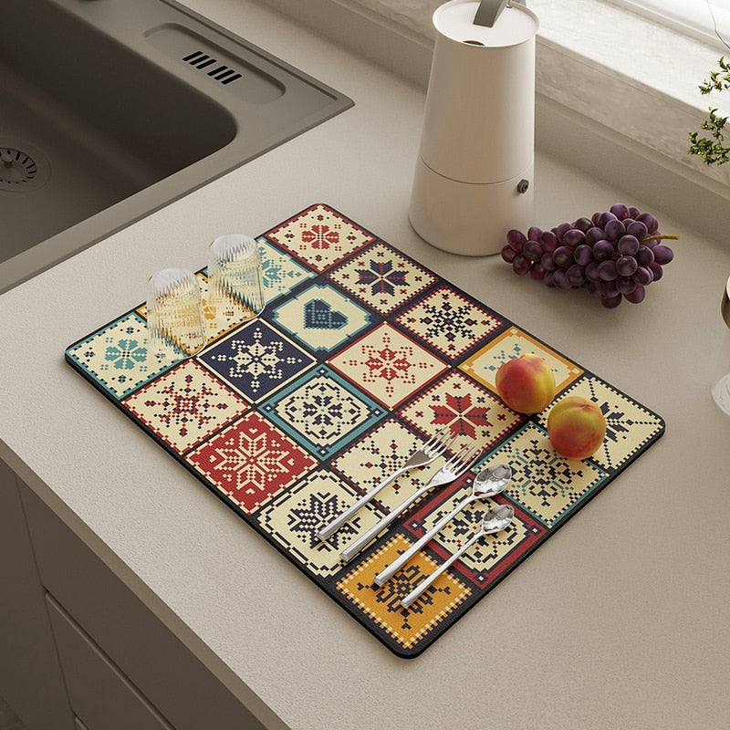 Colorful kitchen dish drying mat with absorbent properties, featuring a patterned design on a countertop next to a sink.