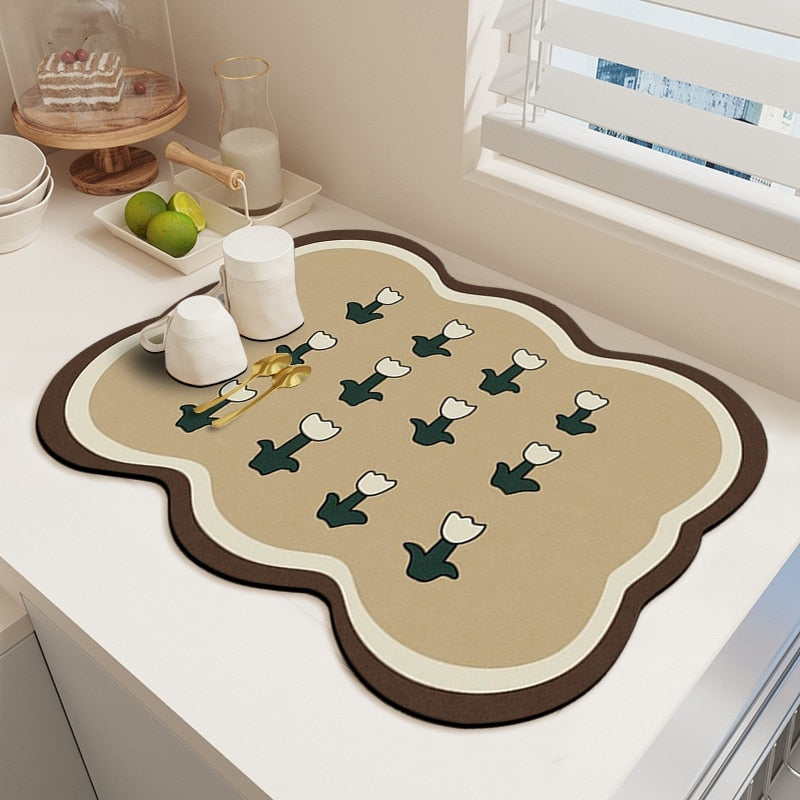 Kitchen dish drying mat absorbent drain pad with floral design on countertop.