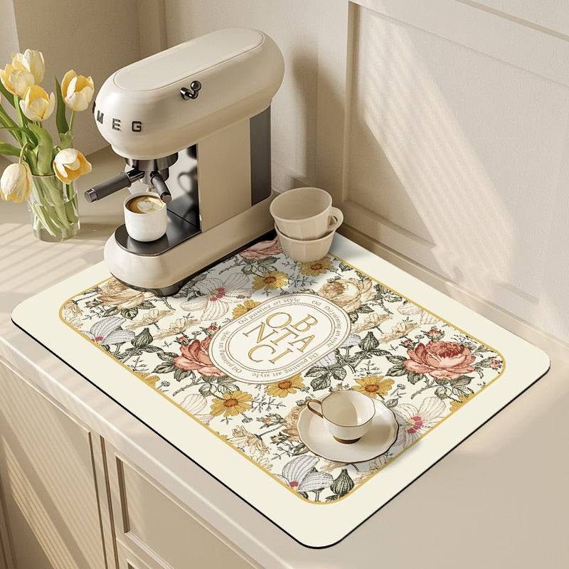 Kitchen dish drying mat with floral design under a coffee maker, absorbent crystal velvet material, for clean and tidy countertops.