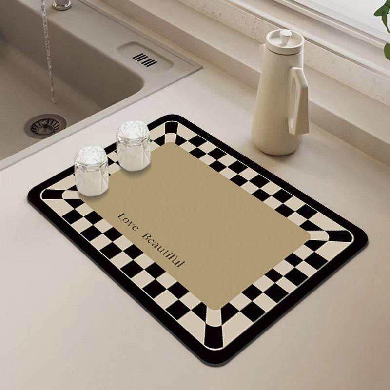 Absorbent kitchen dish drying mat with checkered design on countertop.