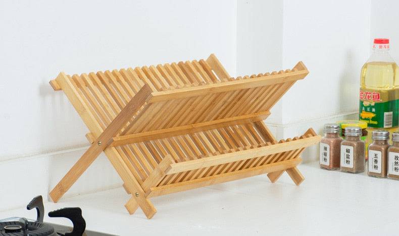 Bamboo double-layer bowl rack with drainage on kitchen counter.
