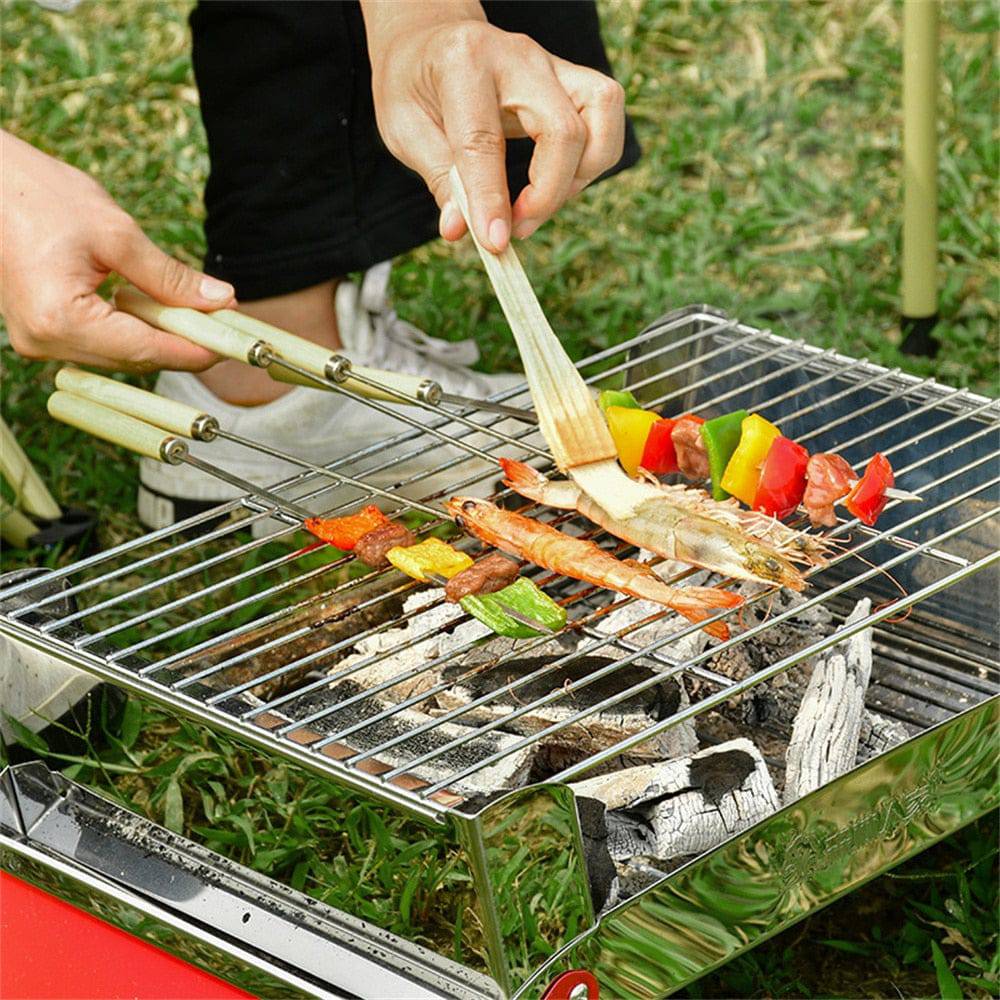 Grilling vegetables and meat on stainless steel skewers over a BBQ.