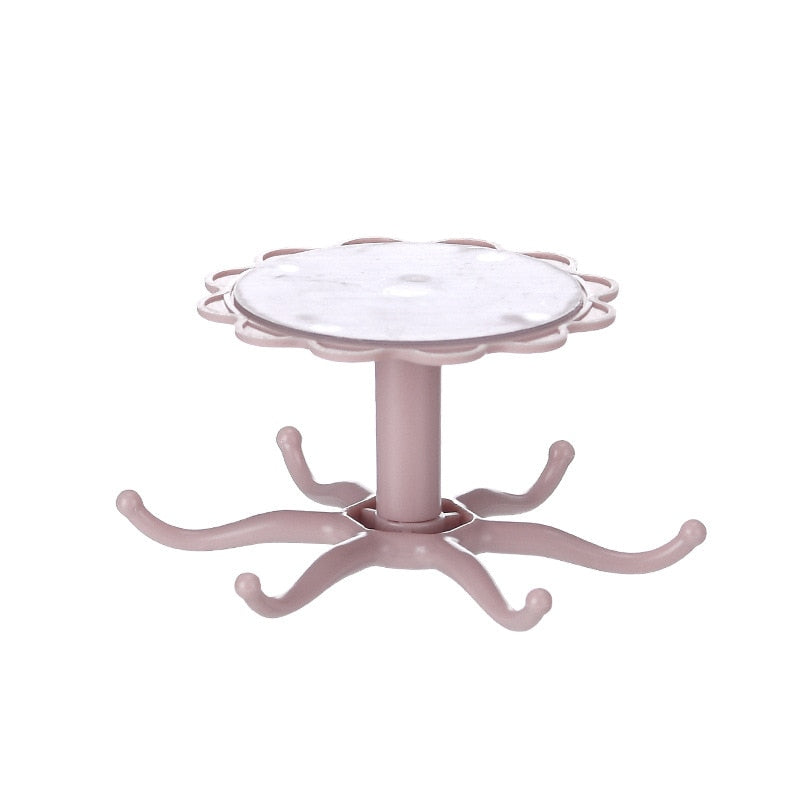 Wall mounted pink kitchenware storage rack with rotary hook design.