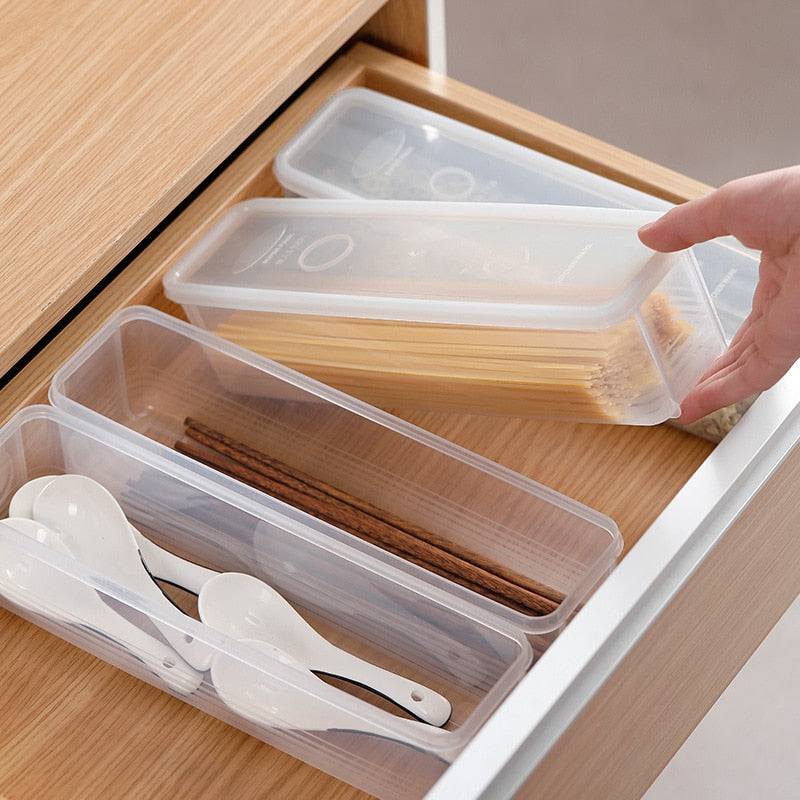 Household cereal preservation storage box in a kitchen drawer holding pasta and utensils.