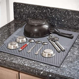 Foldable insulated soft rubber dishes protector sink mat in gray on countertop with kitchenware.