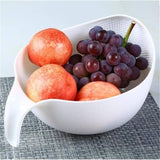 Rice washer and quinoa strainer with handle, holding fruits.