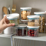Sealed ring bottles kitchen storage box transparent food canister on shelf, displaying preserved foods.
