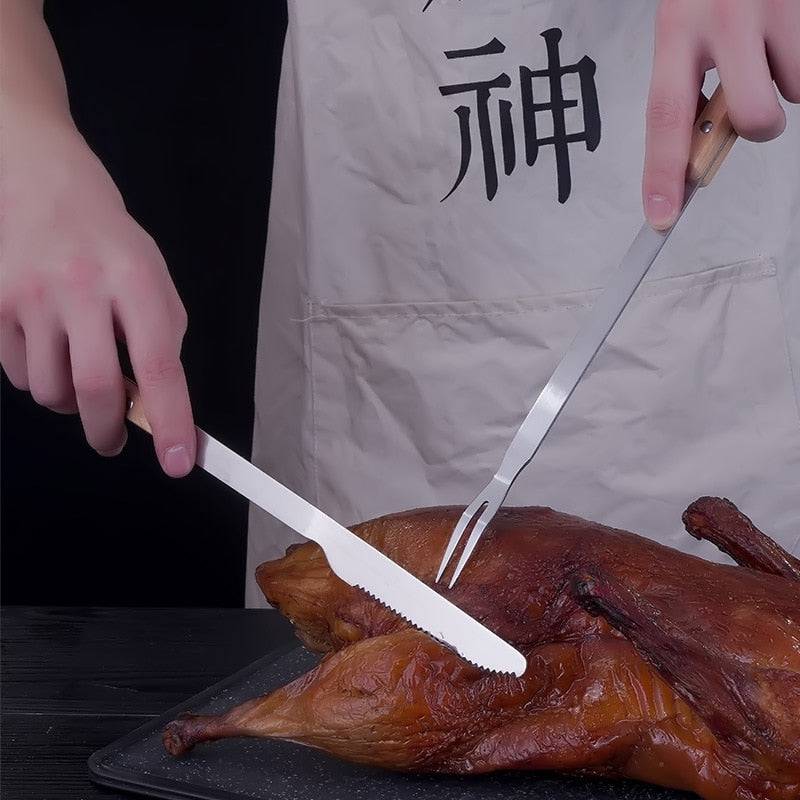 Stainless steel roast lamb knife and fork set used for carving roasted lamb on a barbecue.
