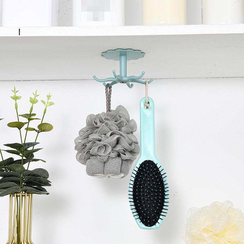 Wall-mounted kitchenware storage rack with 360° rotary hook, holding bathroom accessories, shown under a shelf.