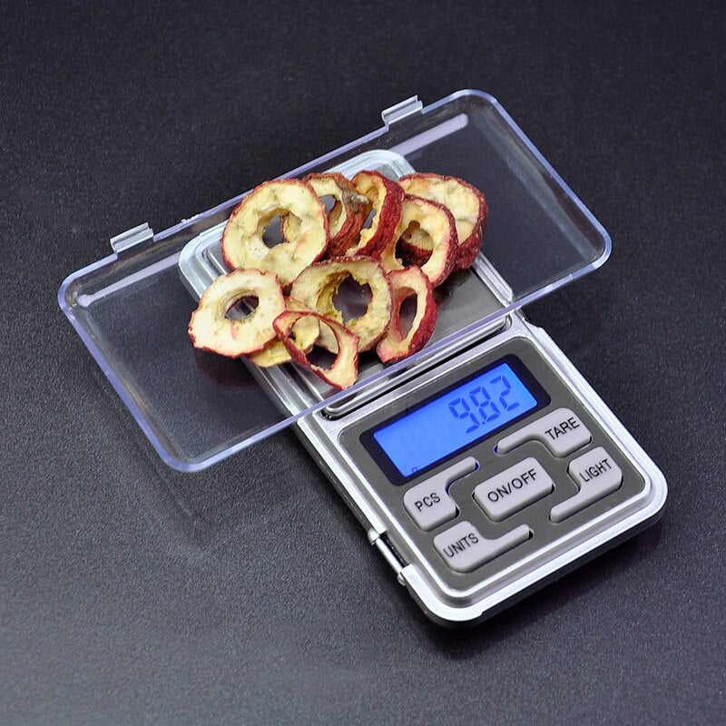 High-precision portable handheld electronic weighing jewelry scale with stainless steel platform and backlit display measuring dried fruit.