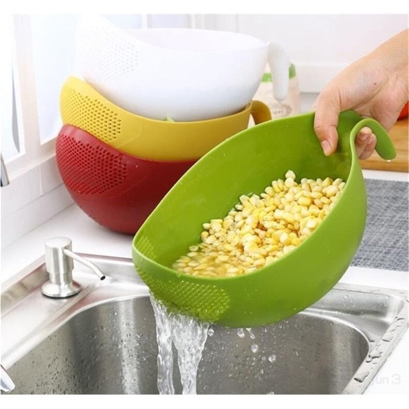 Green rice washer quinoa strainer with handle rinsing corn over kitchen sink.