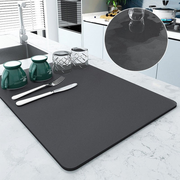 Large kitchen super absorbent draining drying mat on countertop with dishes and utensils.