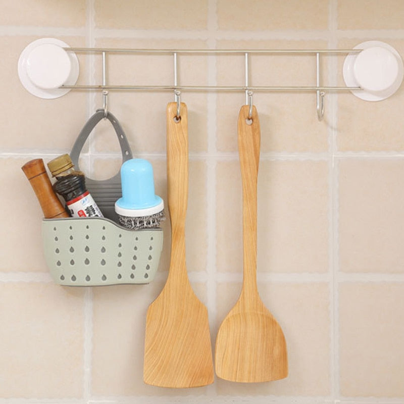 Adjustable plastic storage drain basket sink holder with drainage holes for kitchen utensils.