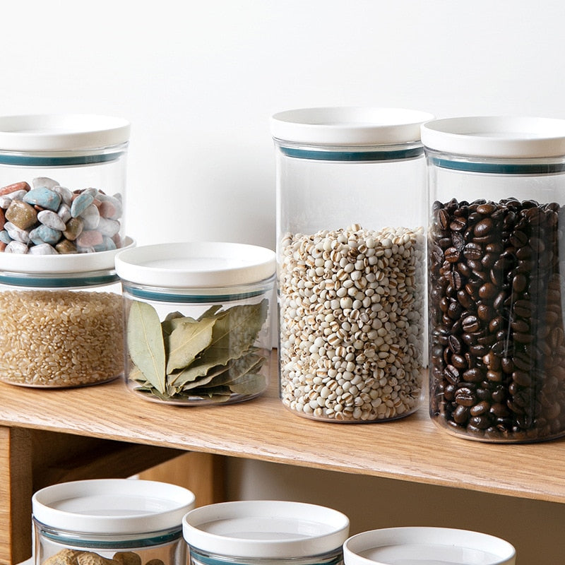 Transparent food canisters with sealed ring design for kitchen storage on a wooden shelf.